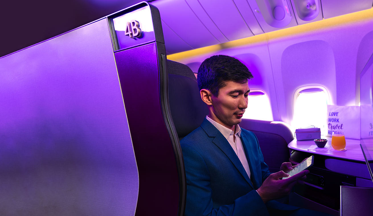 Image of a businessman in a QR Qsuite cabin.